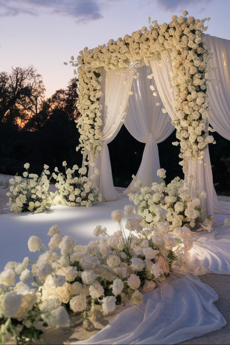 Luxury white wedding floral installation featuring a romantic floral arch, draping fabric, and abundant ceremony flowers for an elegant Las Vegas wedding.